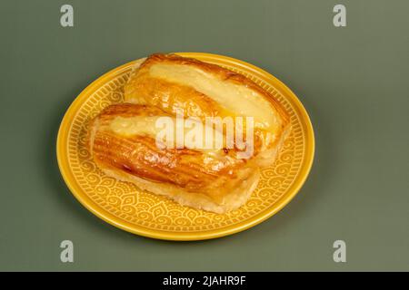 Brasilianisches Süßbrot aus der Bäckerei auf gelbem Teller und grünem Hintergrund Stockfoto