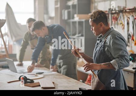 Verschwommene Aufnahme einer Tischlerin, die handgefertigte Möbel in der Produktionswerkstatt entwirft, Kopierraum Stockfoto