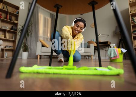 Happy African American Lady Wischboden Reinigungszimmer Zu Hause Stockfoto