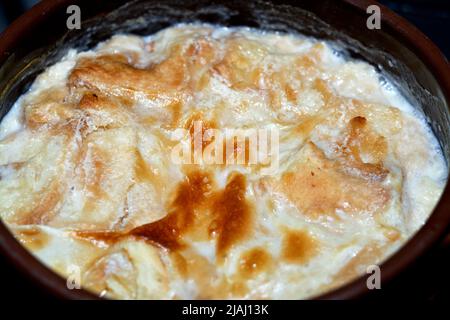 Traditionelle arabische ägyptische östliche Dessertküche namens Om Ali, ägyptisches Brot Pudding in einer braunen Schüssel Töpfereiauflauf aus Milch, ägyptische bre Stockfoto