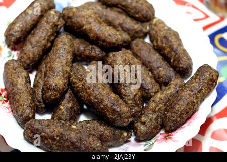 Ägyptische arabische traditionelle Küche mit Hackfleisch, genannt Kofta, gegrillt auf einem Holzkohlegrill, selektiver Fokus auf einen Haufen und Stapel gegrillter Mea Stockfoto