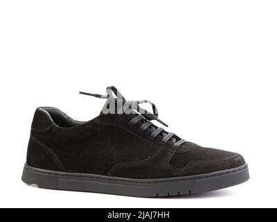 Klassische Sneakers aus schwarzem Wildleder mit Schnürsenkeln. Lässiger Herrenlook. Schwarze Gummisohlen. Isolierte Nahaufnahme auf weißem Hintergrund. Rechte Seitenansicht Stockfoto