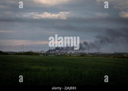 Lysytschansk, Ukraine. 28.. Mai 2022. Eine Rauchkette ist in einer Fabrik aus Lysytschansk, Luhansk, zu sehen. Während russische Truppen die Offensive aus verschiedenen Richtungen starten und hoffen, ukrainische Vorräte und Verstärkungen abzuschneiden und die volle Kontrolle über das Gebiet Luhansk zu erlangen, wird die Stadt Lyschansk, die Severodoonetsk verbindet, schwer bombardiert und belagert. Kredit: SOPA Images Limited/Alamy Live Nachrichten Stockfoto