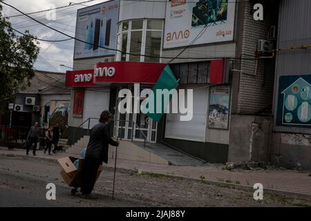 Lysytschansk, Ukraine. 28.. Mai 2022. Eine Frau steht auf der Straße von Lysytschansk, Luhansk. Während russische Truppen die Offensive aus verschiedenen Richtungen starten und hoffen, ukrainische Vorräte und Verstärkungen abzuschneiden und die volle Kontrolle über das Gebiet Luhansk zu erlangen, wird die Stadt Lyschansk, die Severodoonetsk verbindet, schwer bombardiert und belagert. Kredit: SOPA Images Limited/Alamy Live Nachrichten Stockfoto