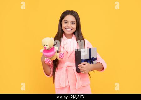 Guten Morgen. Kid tragen weichen Nachthemd spielen mit Spielzeug. Kind in gemütlichen Nachtwäsche. Haut Schönheit. Stockfoto