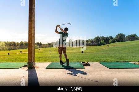 Junger Mann, der im Sommer Golf spielt. Nicht erkennbare Person. Stockfoto