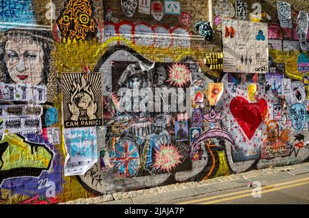 Grafitti und Street Art an einer Wand in der Buxton Street an der Brick Lane in London, Großbritannien. Stockfoto