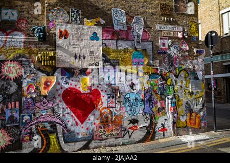 Grafitti und Street Art an einer Wand in der Buxton Street an der Brick Lane in London, Großbritannien. Stockfoto