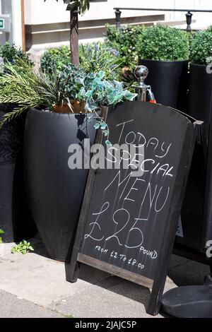 Eine Tafel mit einem Schild mit dem Today's Menu, das in Kreide darauf geschrieben ist. Die Schrift ist im Regen gelaufen. £25 Stockfoto