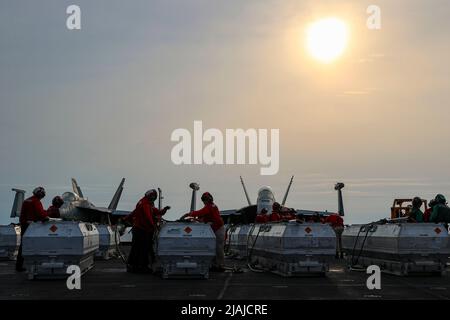 PHILIPPINISCHE SEEFAHRER (20. Mai 2022) bereiten sich darauf vor, vom Flugdeck des Flugzeugträgers USS Abraham Lincoln (CVN 72) aus Munitionsmittel zum Flugzeugträger USS Ronald Reagan der Nimitz-Klasse (CVN 76) zu transportieren. Die Abraham Lincoln Strike Group befindet sich im geplanten Einsatzgebiet der US-Flotte für 7., um die Interoperabilität durch Allianzen und Partnerschaften zu verbessern und gleichzeitig als reaktionsfähige Truppe zur Unterstützung einer freien und offenen Region im Indo-Pazifik-Raum zu dienen. (USA Navy Foto von Mass Communication Specialist 3. Class Javier Reyes) Stockfoto