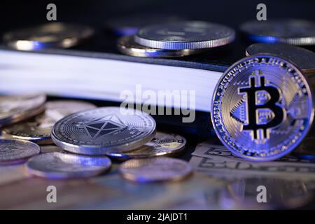 Bitcoin-Münze auf US-Dollar und Notizbuch Stockfoto