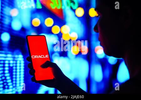 Brasilien. 30.. Mai 2022. In dieser Abbildung hält eine Frau mit Silhouetten ein Smartphone mit dem Oracle Corporation-Logo auf dem Bildschirm. (Bild: © Rafael Henrique/SOPA Images via ZUMA Press Wire) Stockfoto