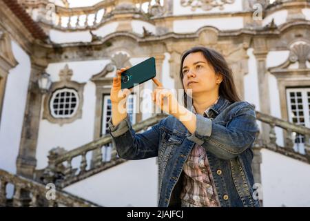 Frau fotografiert mit ihrem Smartphone im Mateus Palace in Vila Real Stockfoto