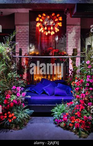Bett mit Kamin mit Blumen und Kerzen dekoriert. Stockfoto