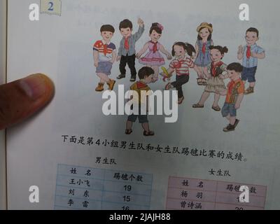 YICHANG, CHINA - 31. MAI 2022 - Ein Bürger zeigt die Illustrationen des zweiten Bandes des veröffentlichten Mathe-Lehrbuchs der vierten Klasse für Grundschulen Stockfoto