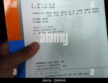 YICHANG, CHINA - 31. MAI 2022 - Ein Bürger zeigt die Illustrationen des zweiten Bandes des veröffentlichten Mathe-Lehrbuchs der vierten Klasse für Grundschulen Stockfoto