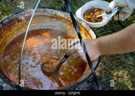 Kochen in einem Kessel auf einem offenen Feuer in der Natur Stockfoto