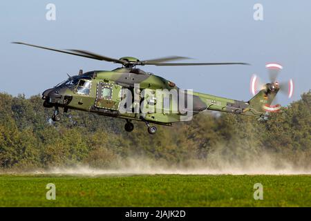 Ein Transporthubschrauber der deutschen Armee NH90 landet auf einem abgelegenen Feld. Stockfoto