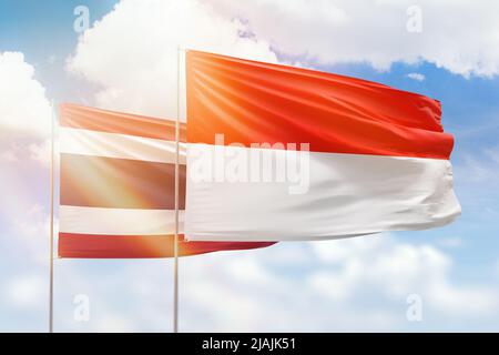 Sonniger blauer Himmel und Flaggen von indonesien und thailand Stockfoto