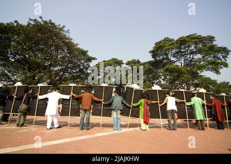 Die Teilnehmer der Kundgebung Bijoy Dibosh (Tag des Sieges) 2007 mit einem Transparent, das den Prozess gegen Kriminelle aus dem Befreiungskrieg im Kendrio Shahid Minar (Monument für die Märtyrer der Sprachbewegung) in Dhaka, Bangladesch, fordert. Am 16. Dezember 1971 erlangte Bangladesch nach einem neunmonatigen Kampf Unabhängigkeit vom regierenden Westpakistan. . Aber auch nach 36 Jahren des Befreiungskrieges sind die Kriegsverbrecher noch nicht vor Gericht gestellt worden. Bangladesch. 16. Dezember 2007. Stockfoto