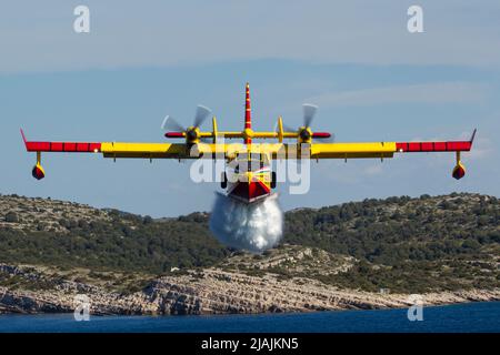 Ein kroatisches Luftwaffe CL-415 Super Scooper Feuerwehrflugzeug, das während eines Trainingsfluges Wasser abgibt. Stockfoto