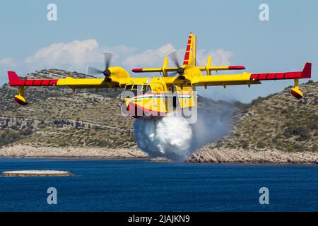 Ein kroatisches Luftwaffe CL-415 Super Scooper Feuerwehrflugzeug, das während eines Trainingsfluges Wasser abgibt. Stockfoto