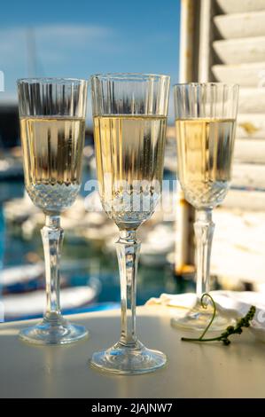 Drei Gläser französischer Champagner Sekt und Blick auf bunte Fischerboote im alten Hafen von Cassis, Provence, Frankreich, Sommerfest in PR Stockfoto