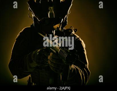 Special Operations Forces Soldat mit Nachtsichtgerät auf Helm, bewaffnet mit Gewehr. Stockfoto