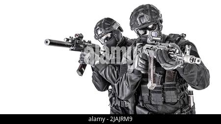 Zwei SWAT-Teamkämpfer in schwarzen Uniformen, bewaffnet mit Sturmgewehren, die sich gegenseitig schützen. Stockfoto