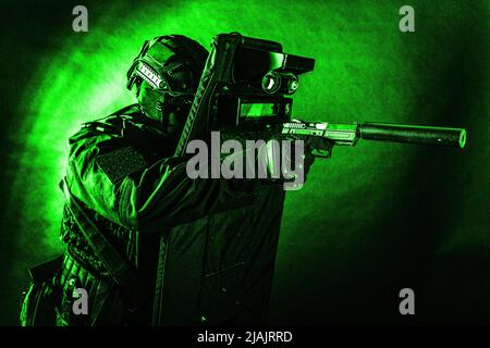 Polizei Spezialeinsätze Kämpfer mit Pistole mit Schalldämpfer ausgestattet, während sich hinter ballistischen Schild. Stockfoto