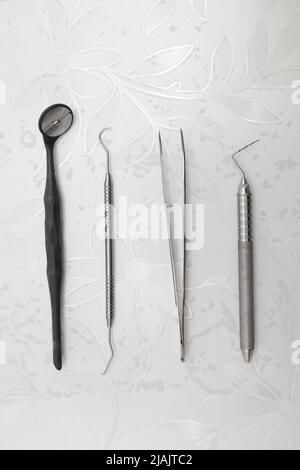 Details der Arbeitstisch mit Metall-Pinzette und Zahnspiegel, Kit von professionellen Werkzeugen für die Intervention mit Zahnarzt bestellt Stockfoto