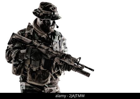 Kommandosoldat in Tarnuniform und Boonie-Hut, bewaffnet mit Dienstgewehr, Studioschuss auf weißem Hintergrund. Stockfoto