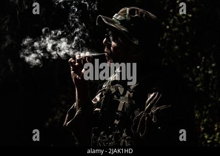 Soldat der Armee raucht nachts Zigarette. Stockfoto