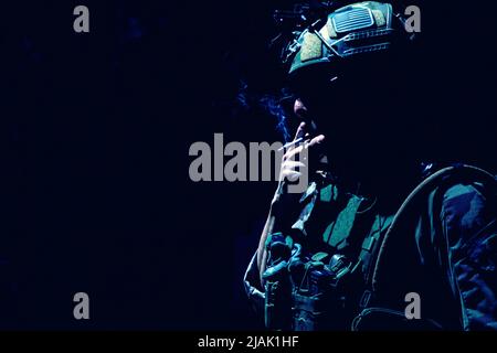 Unaufigartiges Studiofoto eines Soldaten, der eine Zigarette raucht. Stockfoto