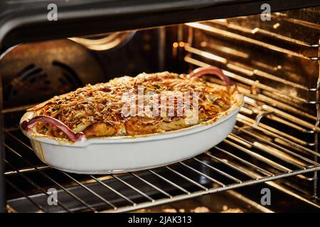 Kuchen mit Kartoffeln und Käse wird im Ofen gebacken. Französisches Gourmetessen Stockfoto