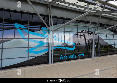 Blauer Flugzeugaufkleber am Terminal des Londoner Southend Airport (SEN) mit Pfeil zur Eingangstür der Ankunft Stockfoto