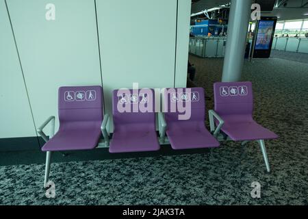 Leere Behindertensitze am Flughafen London Stansted im Wartebereich vor dem Einsteigen Stockfoto