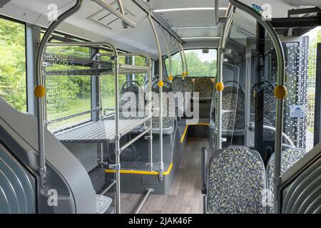 Innerhalb eines Flughafenbusses von London Stansted. Leere Sitze, offene Tür und Gepäckablage Stockfoto