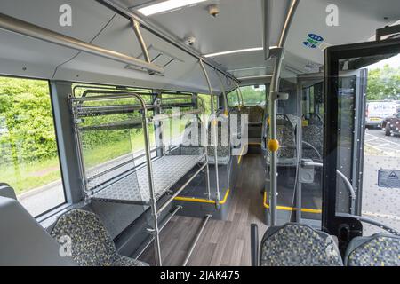 Innerhalb des Flughafenbusses von London Stansted. Leere Sitze, offene Tür und Gepäckablage Stockfoto