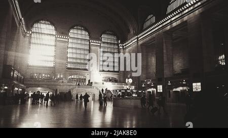 Retro-Vintage-Foto von Grand Central Station am Morgen mit ein paar Pendlern und einem größtenteils leeren Terminal, die Sonne strömt durch die Fenster Stockfoto