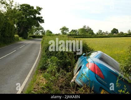 Mai 2022 - Peugeot Auto in einem Graben an einer Landstraße, gleich morgens nach einem Wochenende, mögliche Trunkenheit am Steuer, Stockfoto