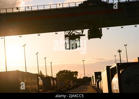 Hamburg, Deutschland. 30.. Mai 2022. Ein Portalkran fährt vor der Abendsonne über das DUSS-Terminal in Hamburg Billwerder. Die deutsche Industrie geht nach wie vor davon aus, dass die Produktion in diesem Jahr unter den Bedingungen des Ukraine-Krieges, der Energieinflation und der Lieferkettenausfälle um knapp 2 Prozent wachsen wird. Quelle: Jonas Walzberg/dpa/Alamy Live News Stockfoto