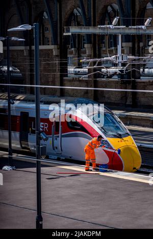 Zugwaschung Kings Cross Station London - LNER-Mitarbeiter waschen einen LNER Azuma-Zug an der Londoner Kings Cross Station. Stockfoto