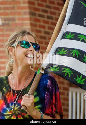 Stacey Shepherd Theis, der Befürworter der Marihuana-Legalisierung und Mitbegründer der „Canna Sense Campaign“, trägt am Samstag, den 7. August 2021, in Fancy Farm, Graves County, KY, USA, eine mit Marihuana-Blättern bedeckte Flagge beim Fancy Farm Picnic 141.. Theis sagte, dass ihr Onkel, Gary Shepherd, ein Marihuanaanbauer war, der von der Staatspolizei von Kentucky bei einem Drogenrazzia im Bezirk Rockcastle 1993, bei dem die Polizei versuchte, 12 Cannabispflanzen zu zerstören, erschoss und getötet wurde. (APEX MediaWire Foto von Joel Wolford) Stockfoto