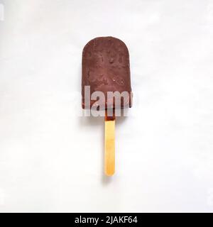 Schokoladeneis auf Holzstab. Leckere Popsicle isoliert auf weißem Hintergrund. Stockfoto