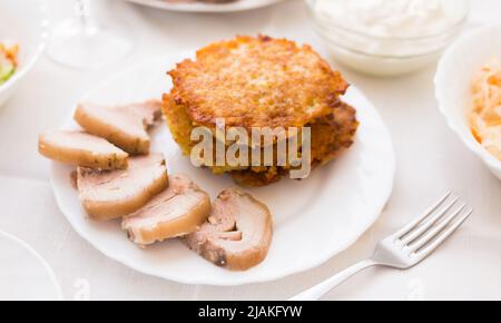 Kartoffelpfannkuchen mit Fleisch auf weißem Teller Stockfoto