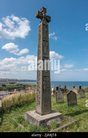 Caedmon's Cross (ein angelsächsischer Dichter aus dem 7.. Jahrhundert) auf dem Friedhof der St Marys Church auf den Klippen mit Blick auf Whitby, North Yorkshire, Großbritannien. Stockfoto