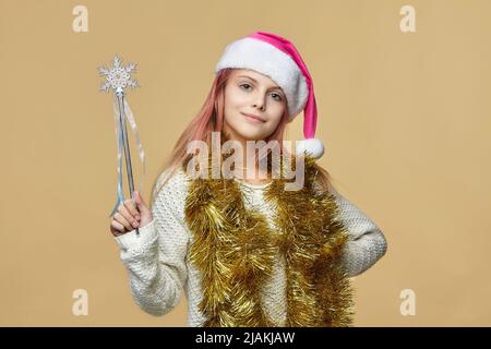 Nettes Mädchen in einem Weihnachtsmann Hut. Foto-Session im Studio auf einem gelben Hintergrund Stockfoto