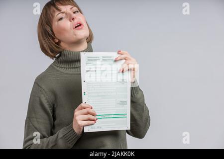 Frau mit Steuerform macht ein irriges Gesicht Stockfoto