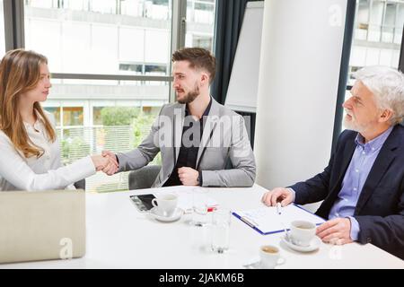 Zwei Geschäftsleute, die sich als Konzept der Zusammenarbeit und Partnerschaft die Hände schütteln Stockfoto
